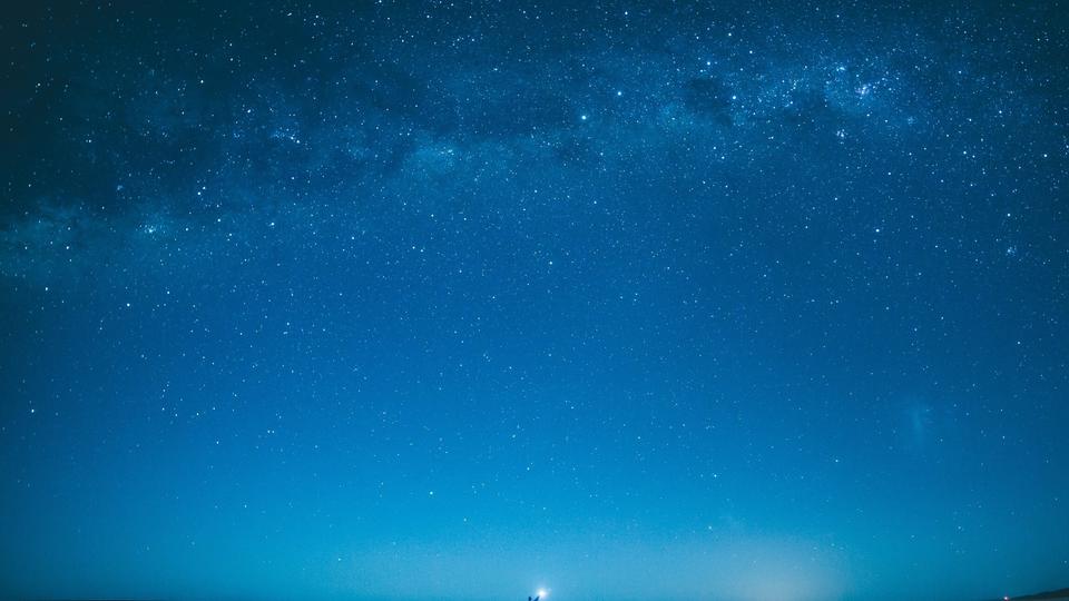 Photo of someone far away holding a light at night. 