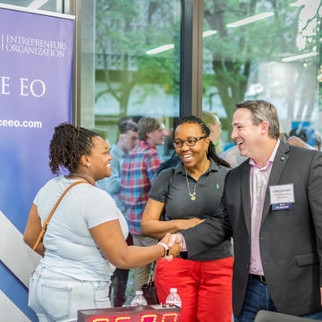 Woman introducing man to another woman at networking event