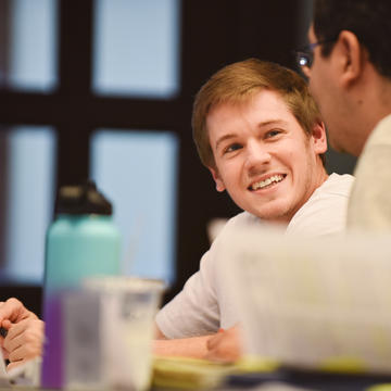 Man working with another student in class