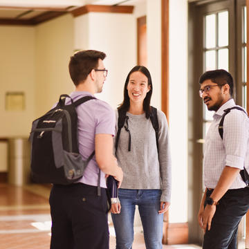 Three students talking in the hallway