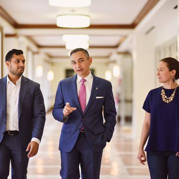 male and female student walking down the hallway with dean peter rodriguez