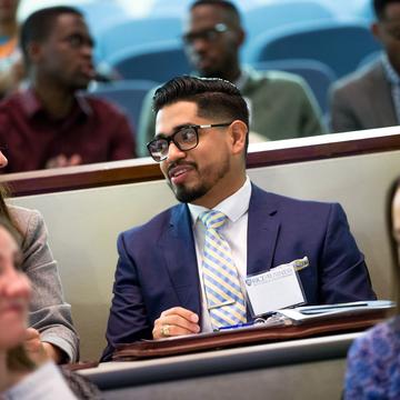 Male student in blue suit at recruiting event