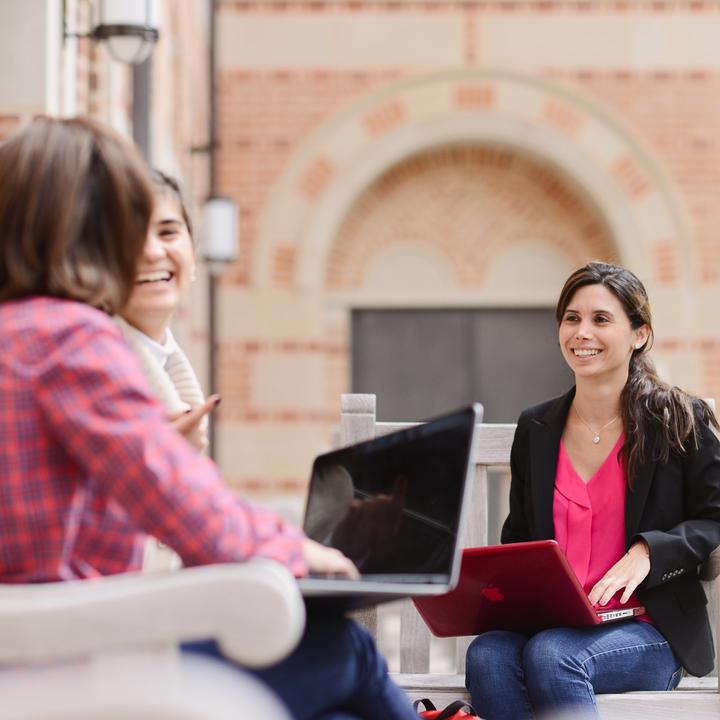 Group of female students working outside on laptops