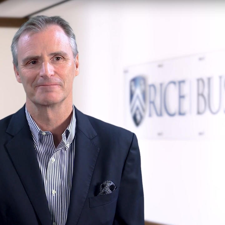 Man standing in front of Rice sign