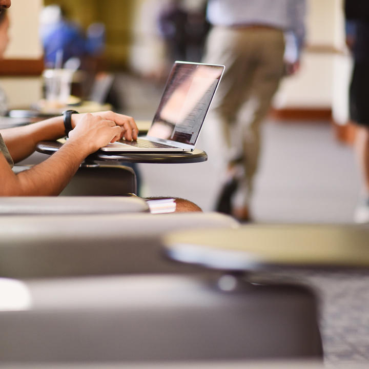 Student on computer in hallway