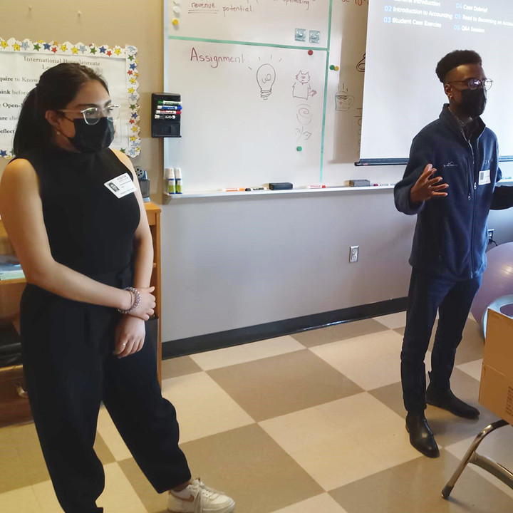MAcc students speaking in front of a class