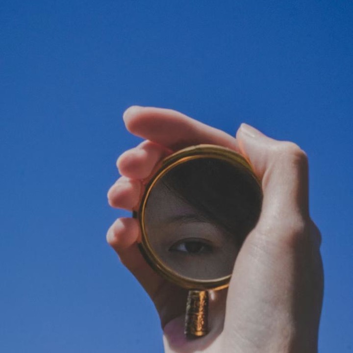 Asian woman holding a small mirror in her hand